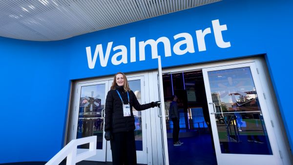 A greeter opens the door to Walmart's CES booth.