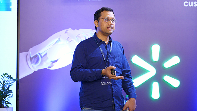 Pratyush Kumar, Co-founder, Sarvam AI delivering a talk on stage in front of a backdrop with the text ‘AI @ Walmart.’ 