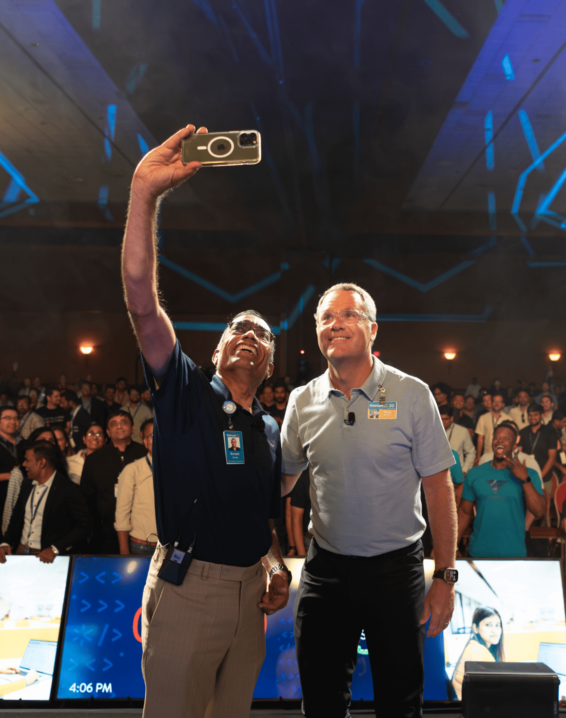 Suresh Kumar, EVP, CTO and CDO, Walmart Inc. (on the left) is shown taking a selfie with Doug McMillon, President and CEO, Walmart Inc. (on the right) with the audience in the background. 